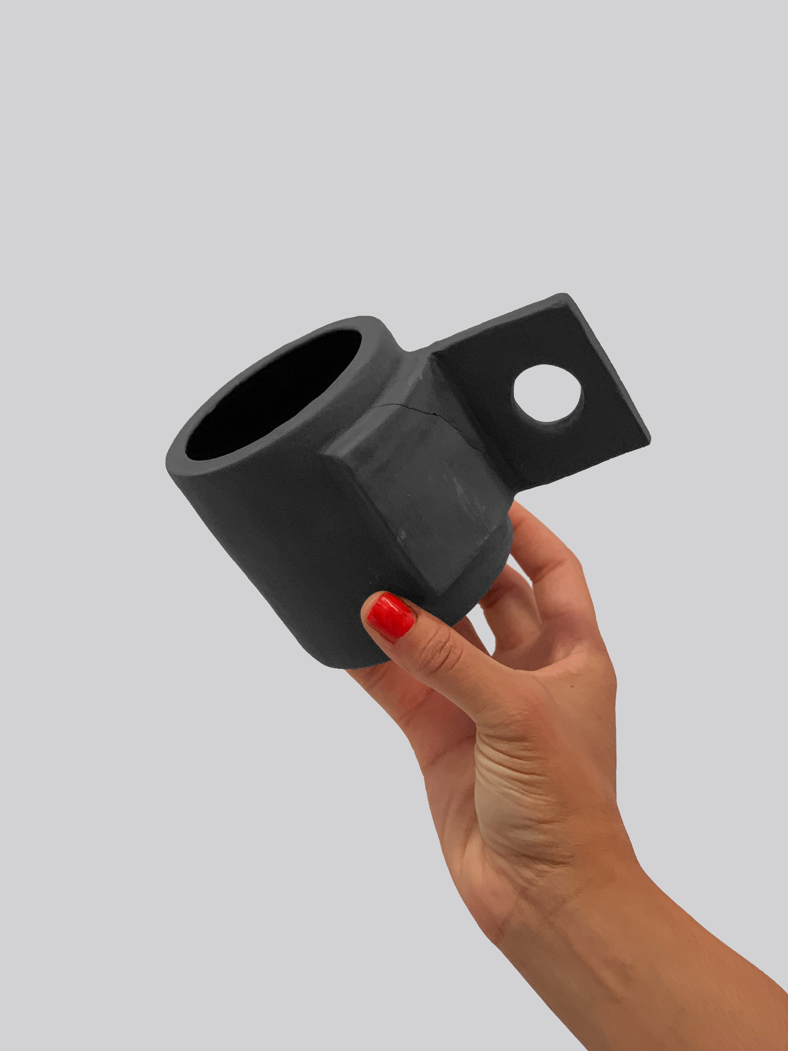 Black matte stoneware ceramic mug with square fold open handle and circle cutout center.