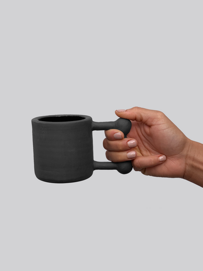 Black matte stoneware ceramic mug with a square shape and ball accents on the corners of the handle.