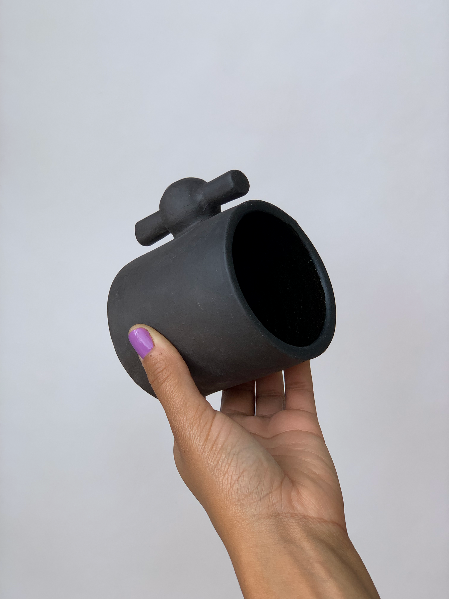 Black matte stoneware ceramic mug with a spigot handle.
