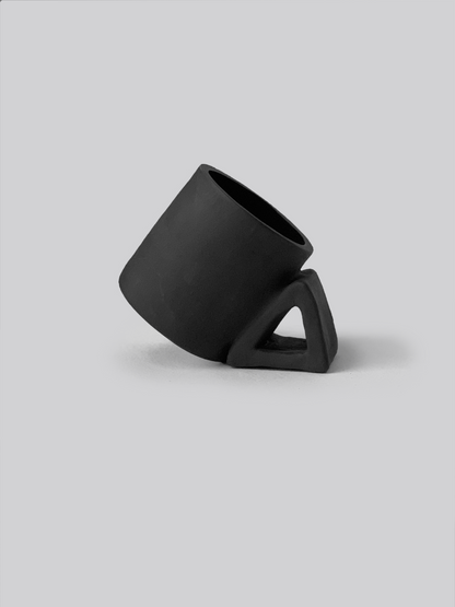 Black matte stoneware ceramic mug with an extended thick triangle shaped handle.