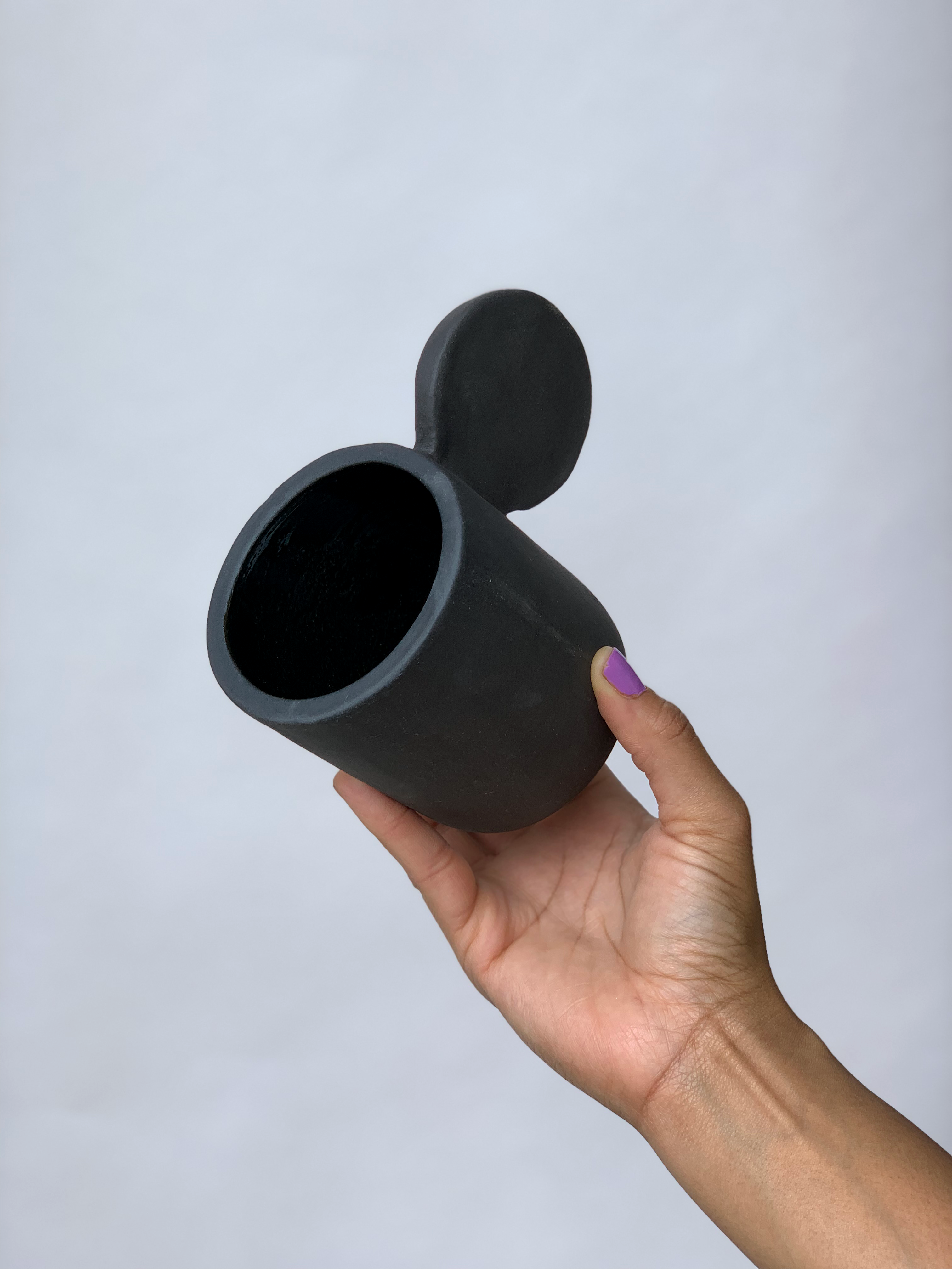 Black matte stoneware ceramic mug with an extended flat full circle handle.