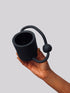 Black matte stoneware ceramic mug with an oval shaped handle on the side of the mug and a ball through the oval shape.