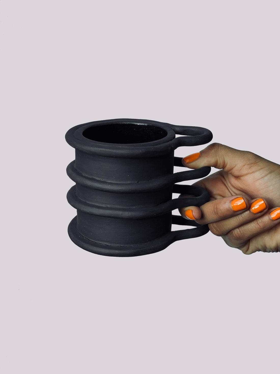 Black matte stoneware ceramic mug with four thin full bar that wrap around the mug and extend outwards as the handles.