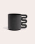 Black matte stoneware ceramic mug with a squiggle shaped handle.