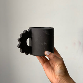 Black matte stoneware ceramic mug with a thick gear handle.