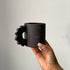 Black matte stoneware ceramic mug with a thick gear handle.