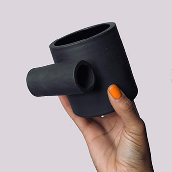 Thrown black matte stoneware ceramic mug with a full side roll as the handle.