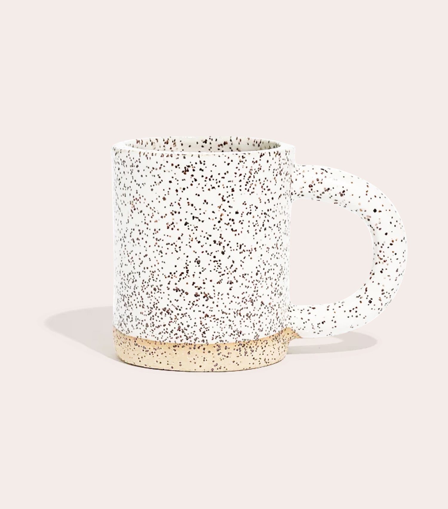 A speckled stoneware mug with a half circular handle. 